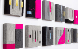 8 box shaped tapestries woven in pink gray and black